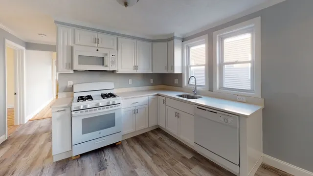a kitchen with cabinets appliances a sink and a window