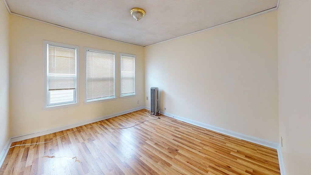 5 Edgar Terrace, Unit 3 Somerville, MA 02145 - Photo 4 of 8 a view of an empty room with wooden floor and a window