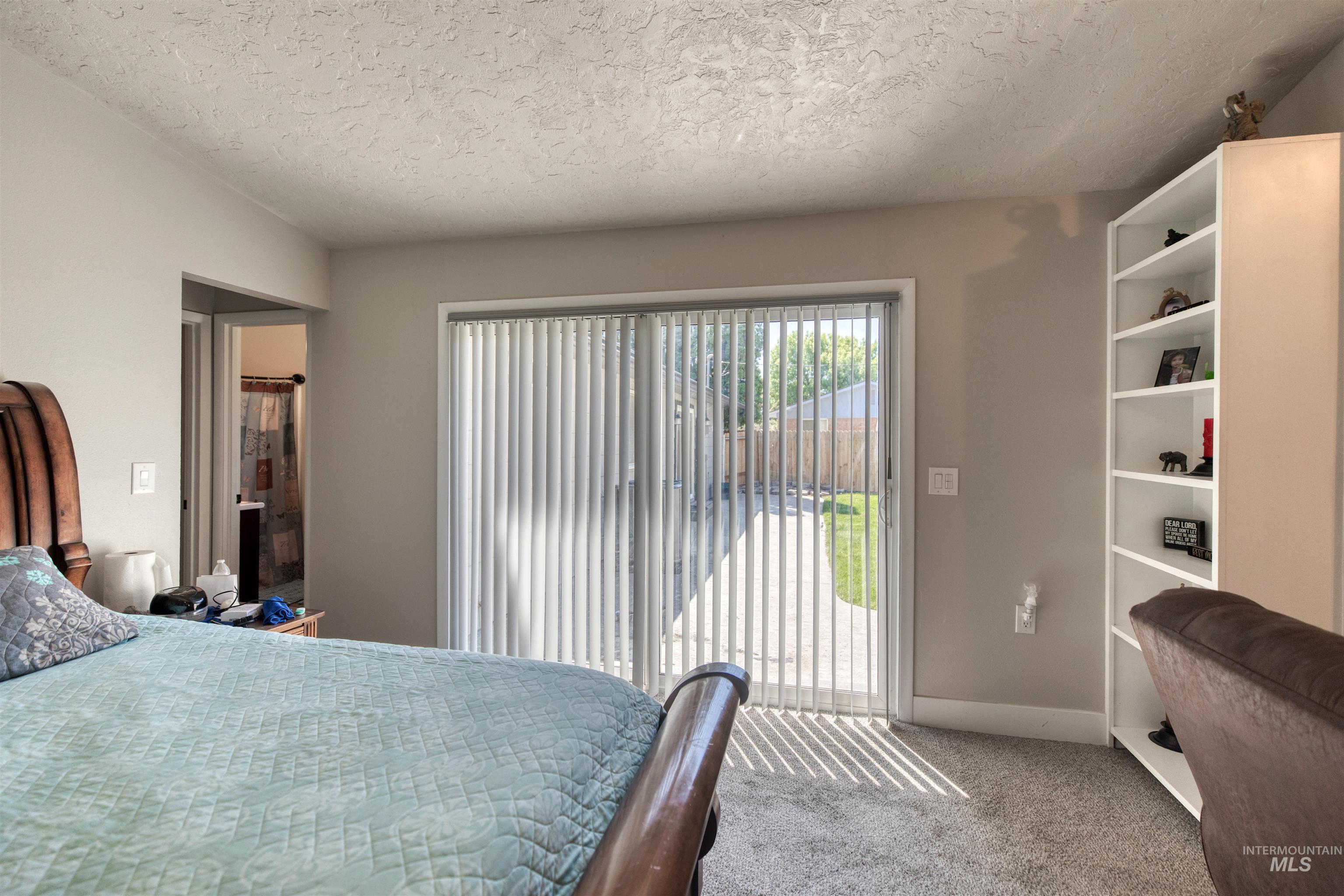 20803 Friends Road Greenleaf, ID 83626 - Photo 12 of 39 Sliding glass door with vertical blinds offering access to a fenced backyard