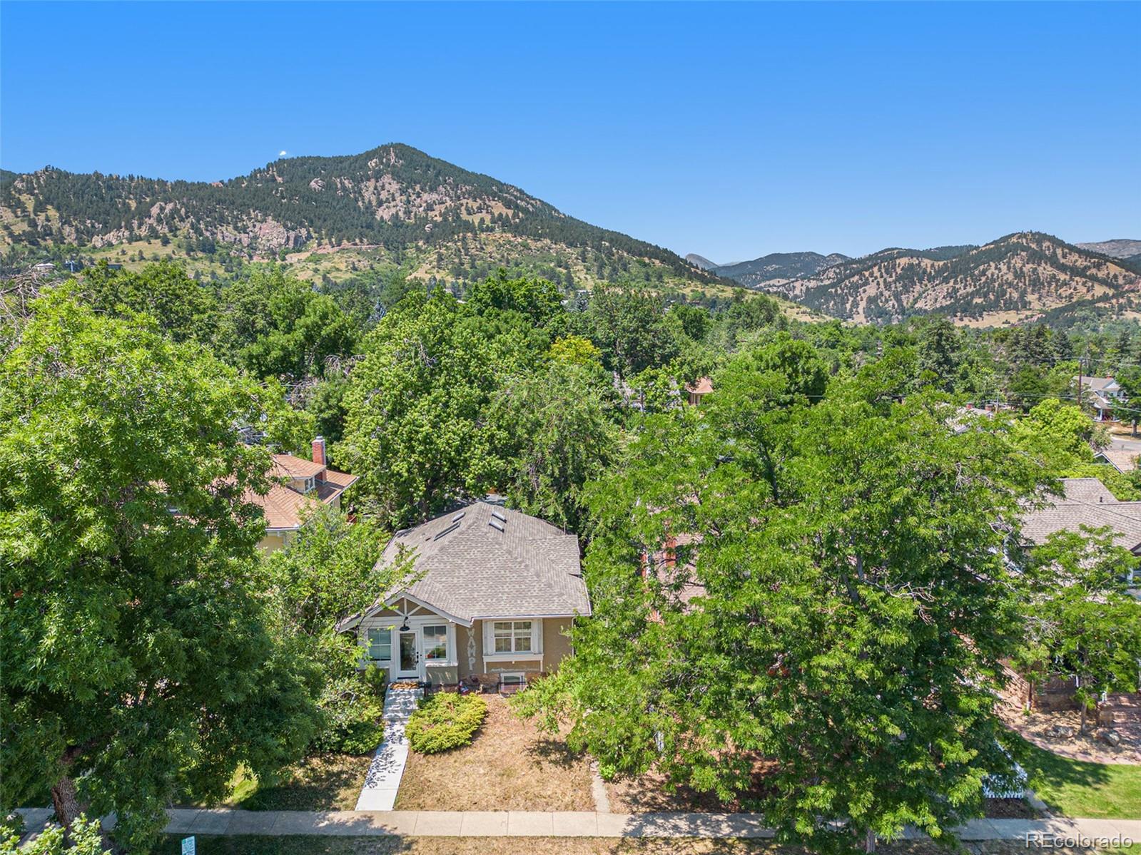 1069 11th Street Boulder, CO 80302 - Photo 22 of 28 a view of a house with a mountain yard and a forest