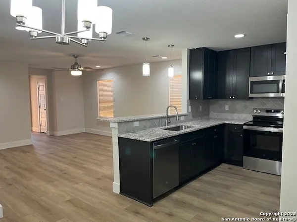 a kitchen with stainless steel appliances granite countertop a refrigerator and a stove