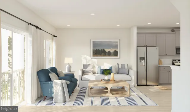 a living room with furniture a large window and stainless steel appliances