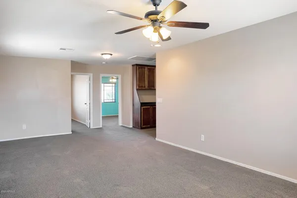 an empty room with windows and fan