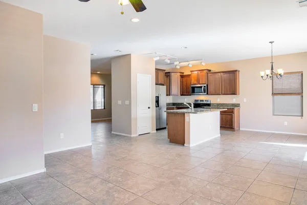 a kitchen with kitchen island granite countertop a sink stove and refrigerator