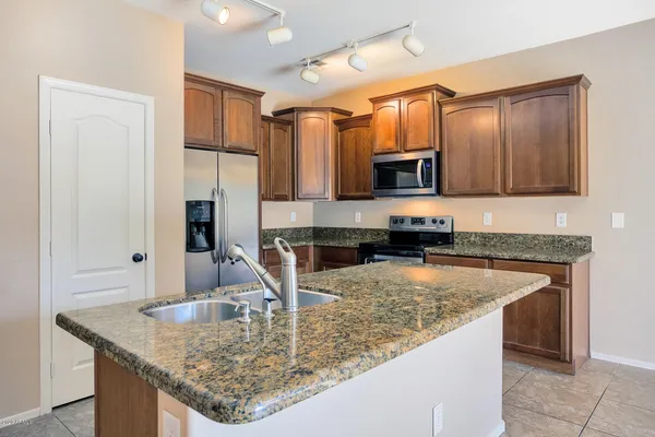 a kitchen with granite countertop a sink stainless steel appliances and cabinets