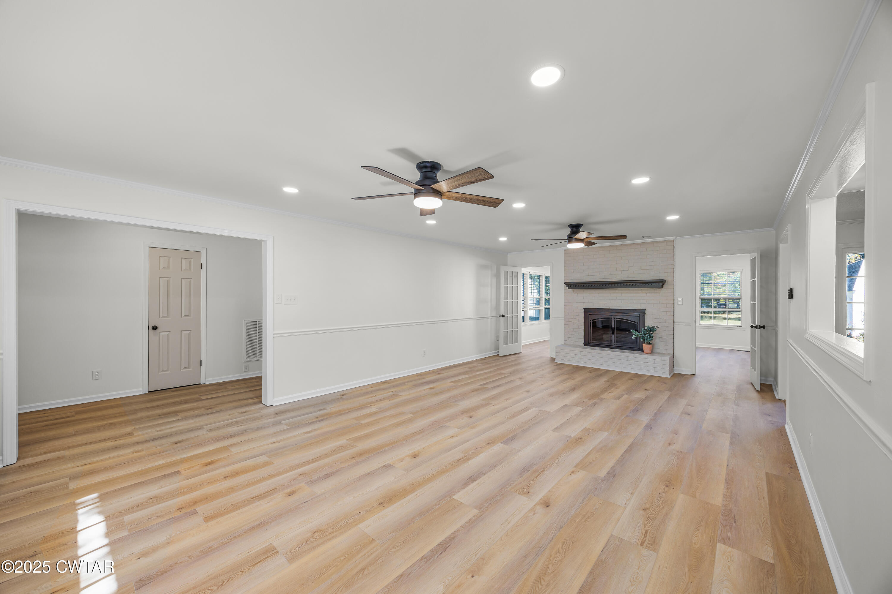 247 Highway 412 Jackson, TN 38305 - Photo 4 of 29 a view of empty room with wooden floor fireplace and windows