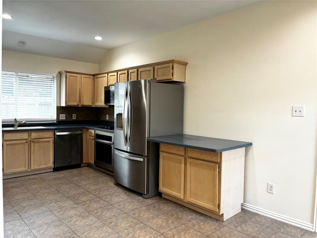 7936 Tournament Road Frisco, TX 75035 - Photo 7 of 28 a kitchen with a refrigerator stove and sink