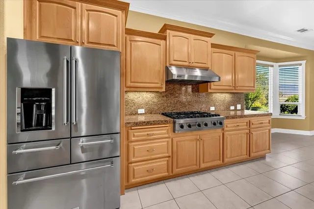 a view of an empty room with wooden floor fireplace and a window