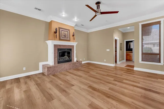a view of an empty room with wooden floor and closet