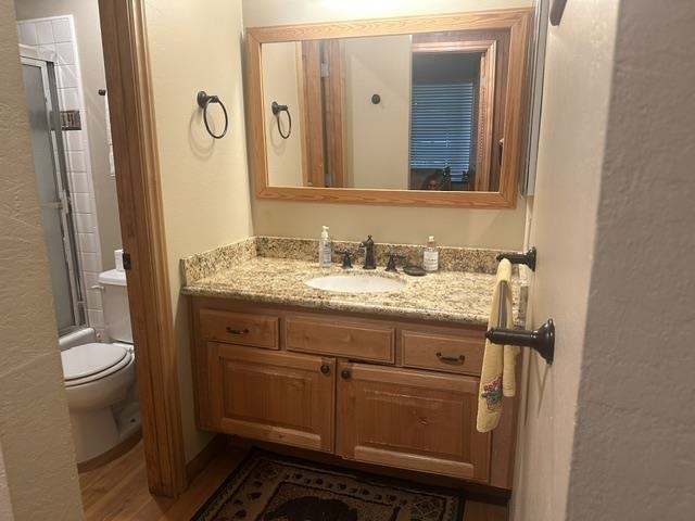 25 Lee Road, Unit 106 Mammoth Lakes, CA 93546 - Photo 8 of 16 Bathroom featuring a wood-finish vanity with an integrated sink, granite countertop, and oil-rubbed bronze fixtures