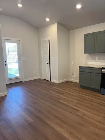 an empty room with wooden floor and cabinet