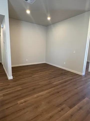 an empty room with wooden floor and entrance