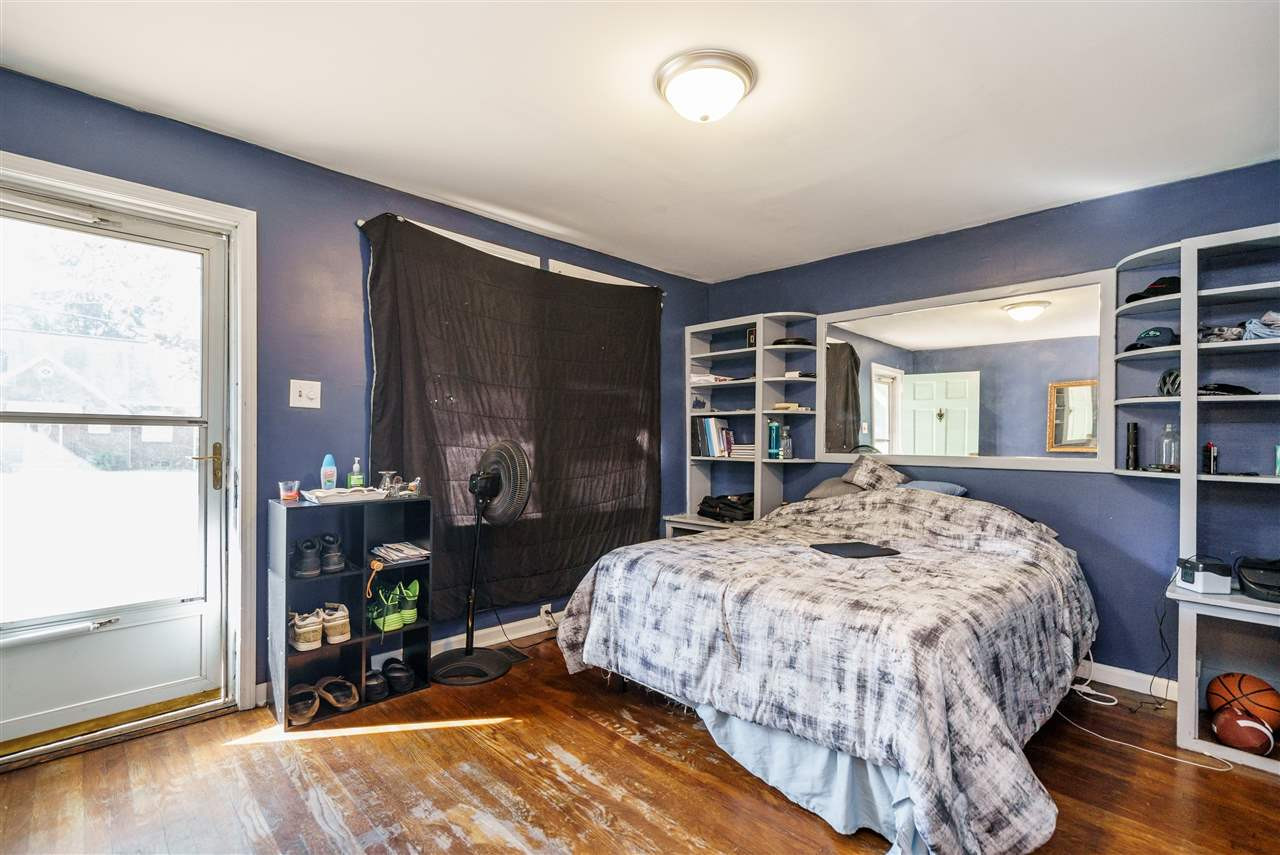 2402 Everett Avenue Raleigh, NC 27607 - Photo 13 of 20 a bedroom with a bed a table and bookshelf