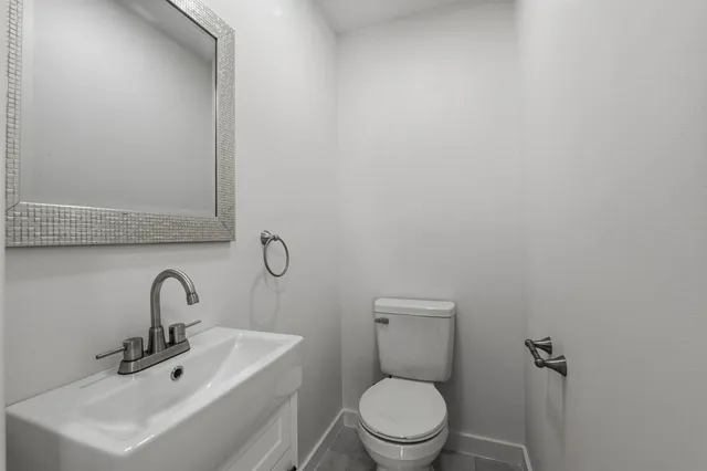 a bathroom with a sink mirror and toilet