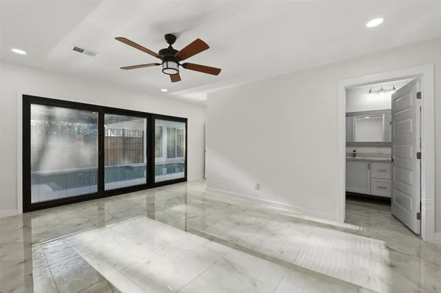 a view of empty room with a ceiling fan and window