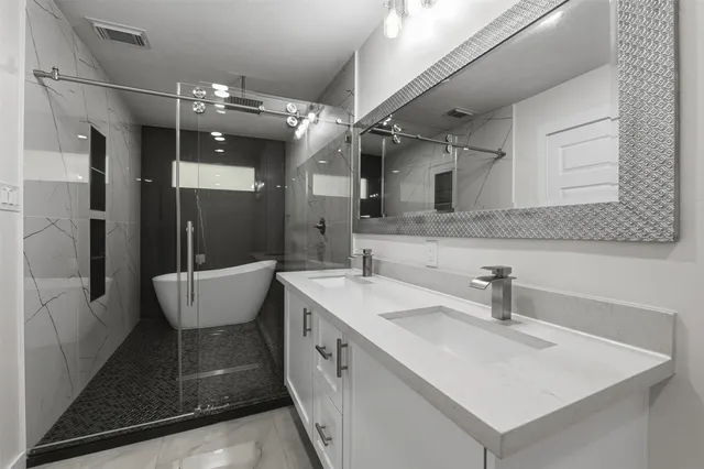 a spacious bathroom with a sink a large mirror and shower