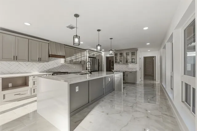 a large kitchen with kitchen island a sink stainless steel appliances and cabinets