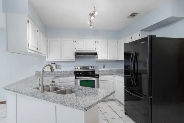 a kitchen with granite countertop a refrigerator and a sink