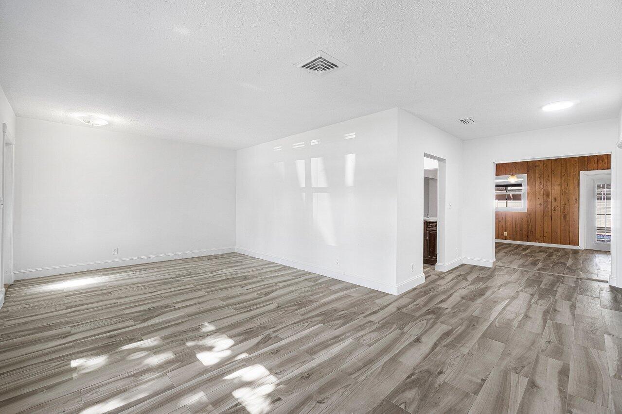 1641 Northwest 9th Street Boca Raton, FL 33486 - Photo 4 of 29 a view of an empty room with wooden floor and a window