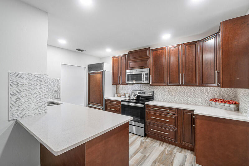 1641 Northwest 9th Street Boca Raton, FL 33486 - Photo 6 of 29 a kitchen with stainless steel appliances granite countertop a sink stove and refrigerator