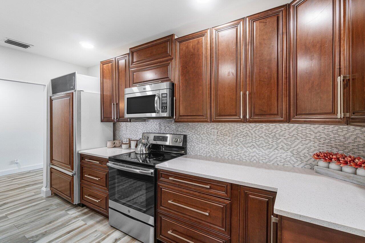 1641 Northwest 9th Street Boca Raton, FL 33486 - Photo 7 of 29 a kitchen with granite countertop stainless steel appliances a stove microwave and refrigerator
