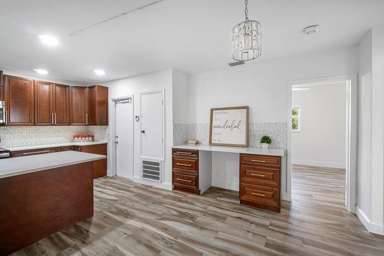 1641 Northwest 9th Street Boca Raton, FL 33486 - Photo 9 of 29 a kitchen with stainless steel appliances a refrigerator and a stove top oven