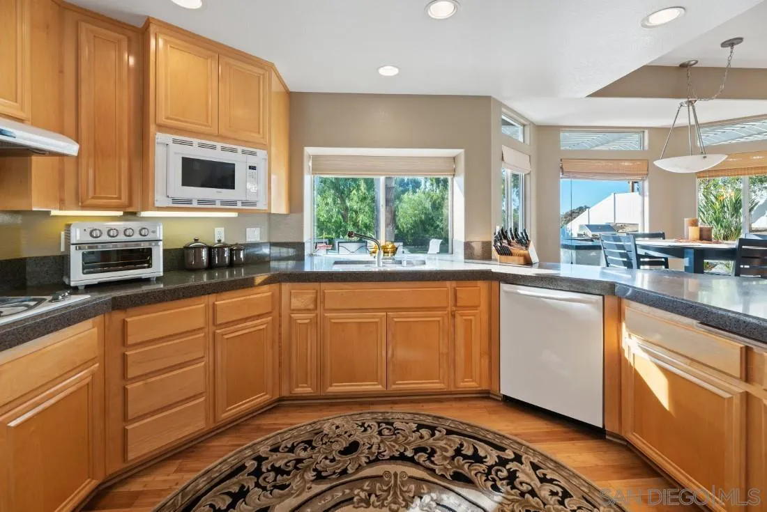 14268 Silver Ridge Road Poway, CA 92064 - Photo 14 of 53 a kitchen with stainless steel appliances kitchen island granite countertop a sink and a stove