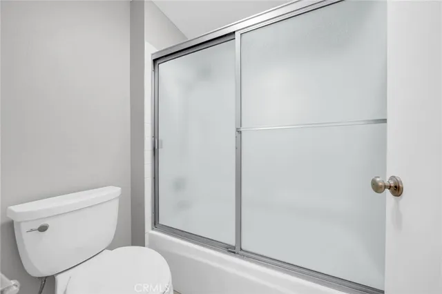 a white toilet sitting next to a shower