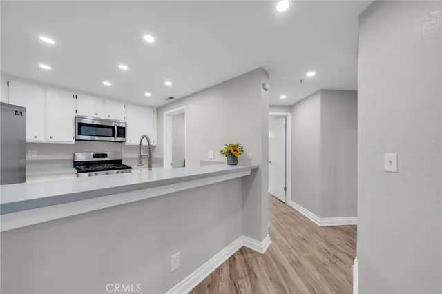 a kitchen with stainless steel appliances a microwave a sink and a refrigerator
