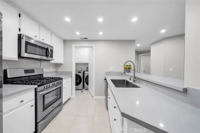 a kitchen with stainless steel appliances granite countertop a sink and a stove