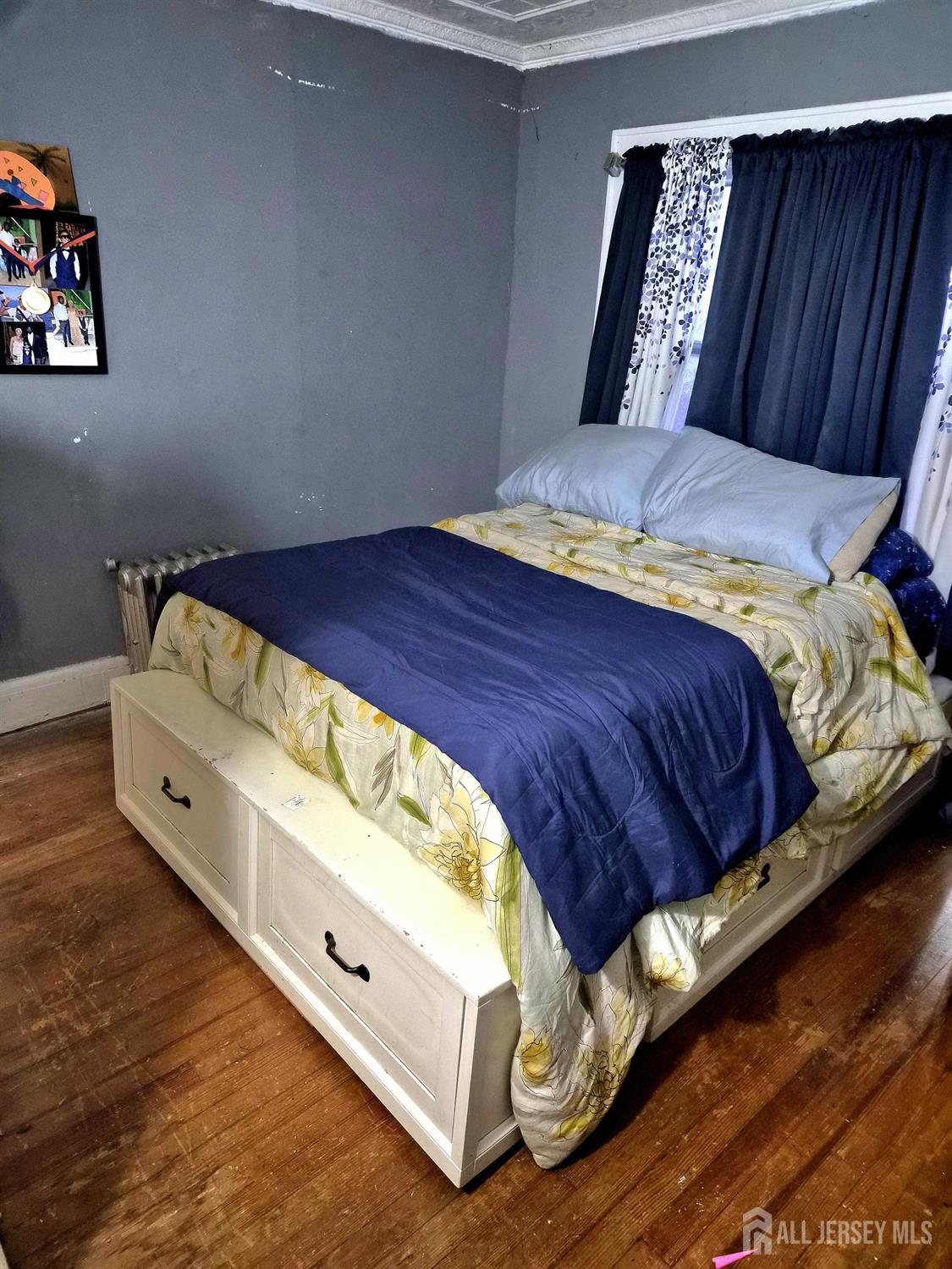 95 Farragut Road North Plainfield, NJ 07060 - Photo 30 of 30 a bed sitting in a bedroom next to a wooden cabinet