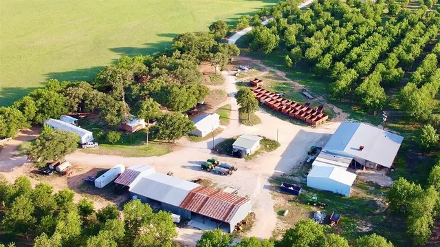 an aerial view of residential house with outdoor space and trees all around