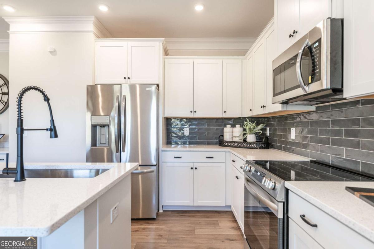 10413 Trellis Lane, Unit (LOT 33) Hampton, GA 30228 - Photo 21 of 39 a kitchen with stainless steel appliances granite countertop a sink dishwasher a refrigerator and cabinets with wooden floor
