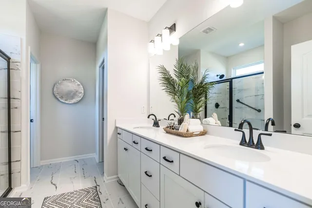 a bathroom with a double vanity sink mirror and shower