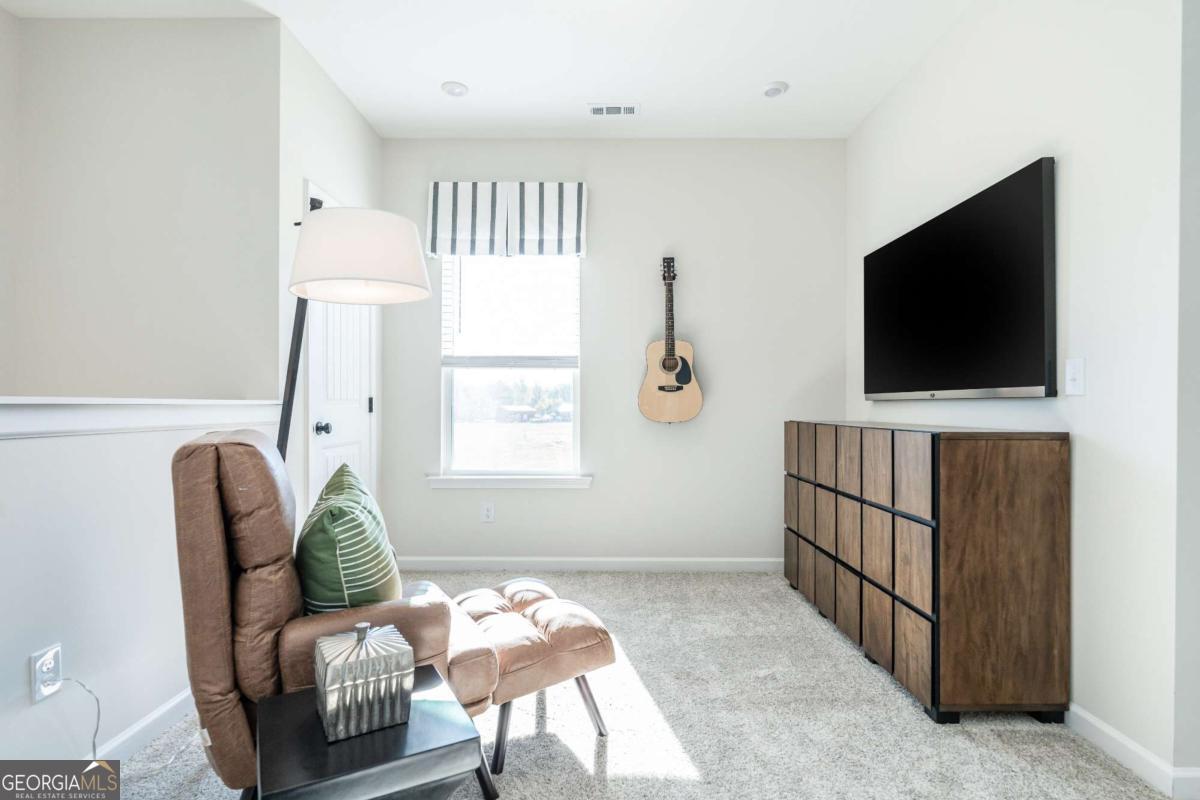 10413 Trellis Lane, Unit (LOT 33) Hampton, GA 30228 - Photo 28 of 39 a living room with furniture and a flat screen tv