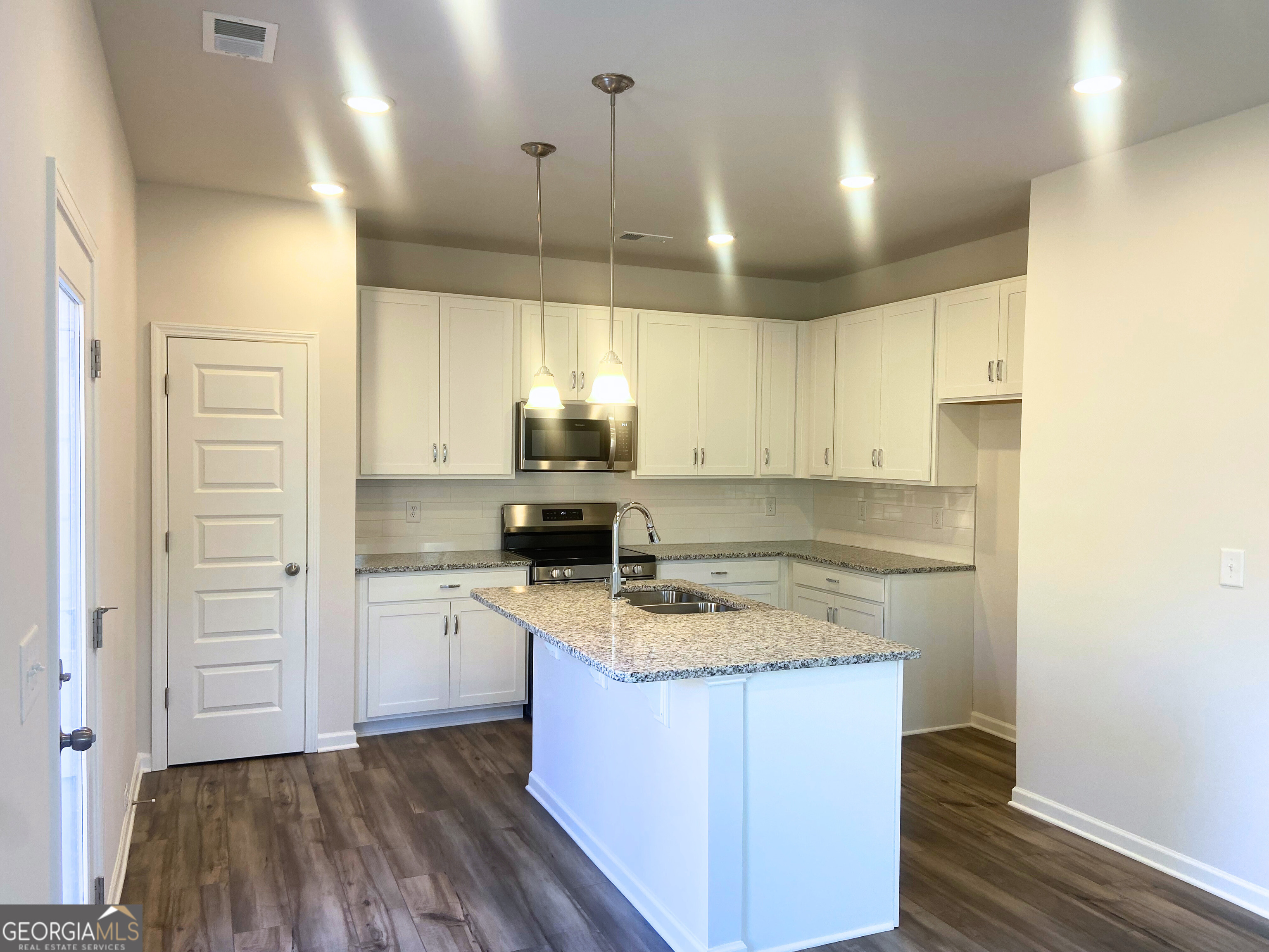 10413 Trellis Lane, Unit (LOT 33) Hampton, GA 30228 - Photo 3 of 39 a kitchen with a sink a stove a refrigerator and cabinets