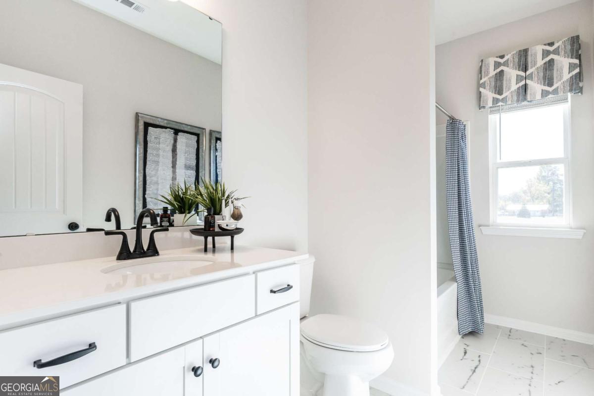 10413 Trellis Lane, Unit (LOT 33) Hampton, GA 30228 - Photo 37 of 39 a bathroom with a sink and a mirror