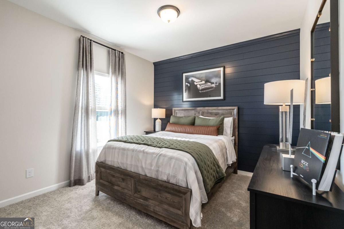 10413 Trellis Lane, Unit (LOT 33) Hampton, GA 30228 - Photo 38 of 39 a bedroom with a bed and wooden floor