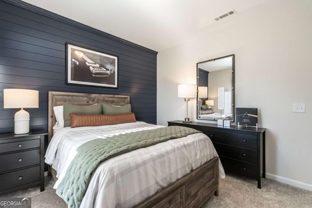 10413 Trellis Lane, Unit (LOT 33) Hampton, GA 30228 - Photo 39 of 39 a bedroom with a bed and a lamp on dresser