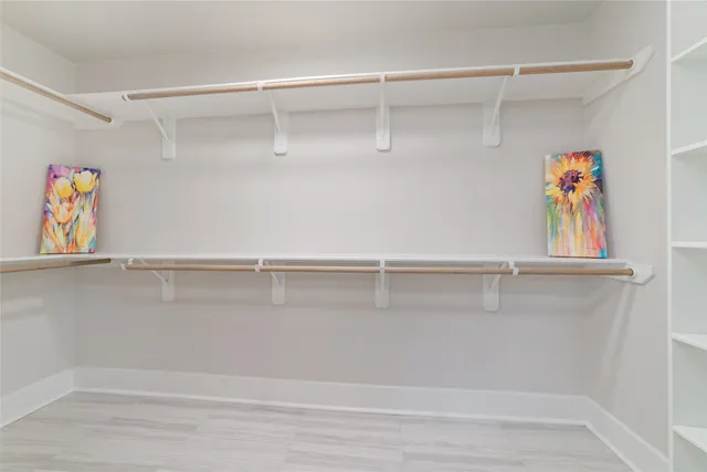 a view of walk in closet with clothes and shoes