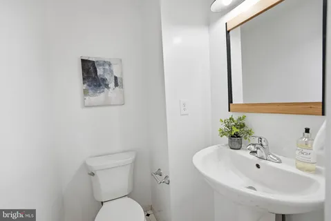a bathroom with a toilet a sink and mirror