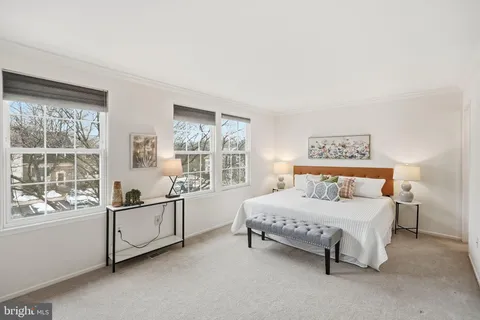 a bedroom with a bed couch and a large window