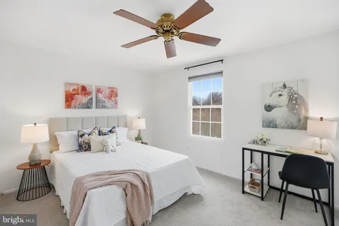 a bedroom with a bed and a table in it with window