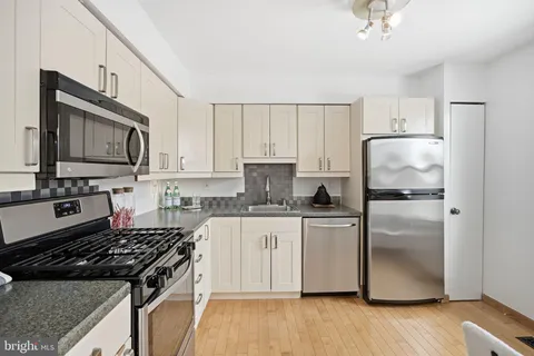 a kitchen with stainless steel appliances granite countertop a stove a refrigerator and a microwave