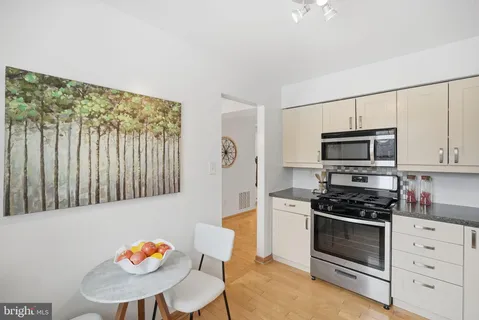 a kitchen with stainless steel appliances a stove a microwave a sink and cabinets