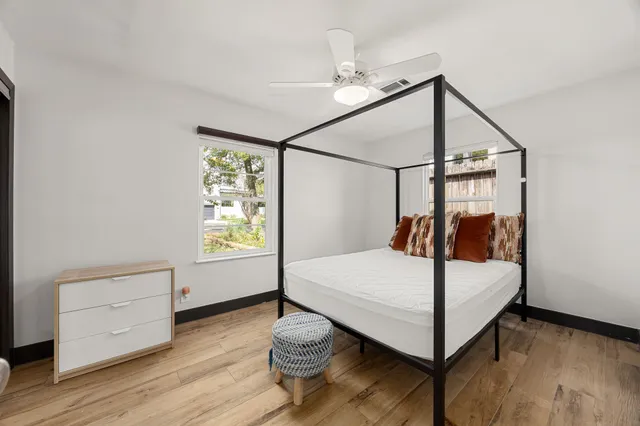 a bed sitting in a bedroom next to a window