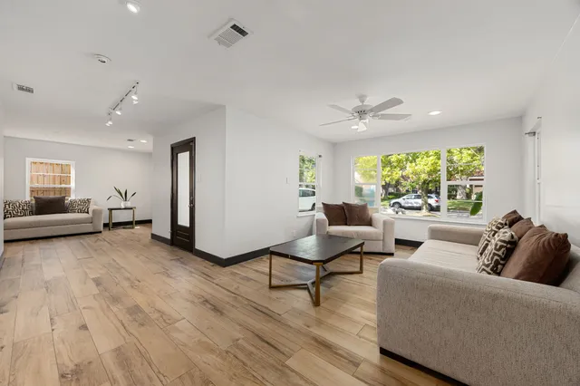 a living room with furniture and a large window with wooden floor
