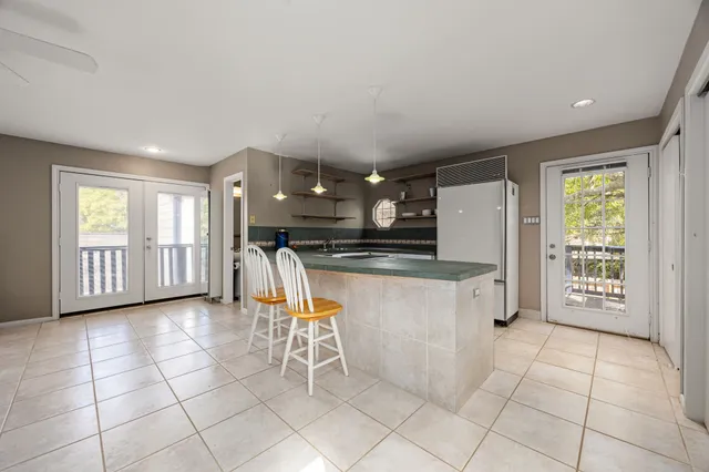 a kitchen with stainless steel appliances kitchen island granite countertop a refrigerator and a sink