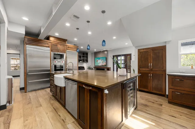 a kitchen with stainless steel appliances granite countertop a sink stove and refrigerator