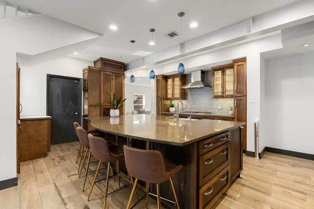 a kitchen with stainless steel appliances granite countertop a sink a stove a refrigerator and island